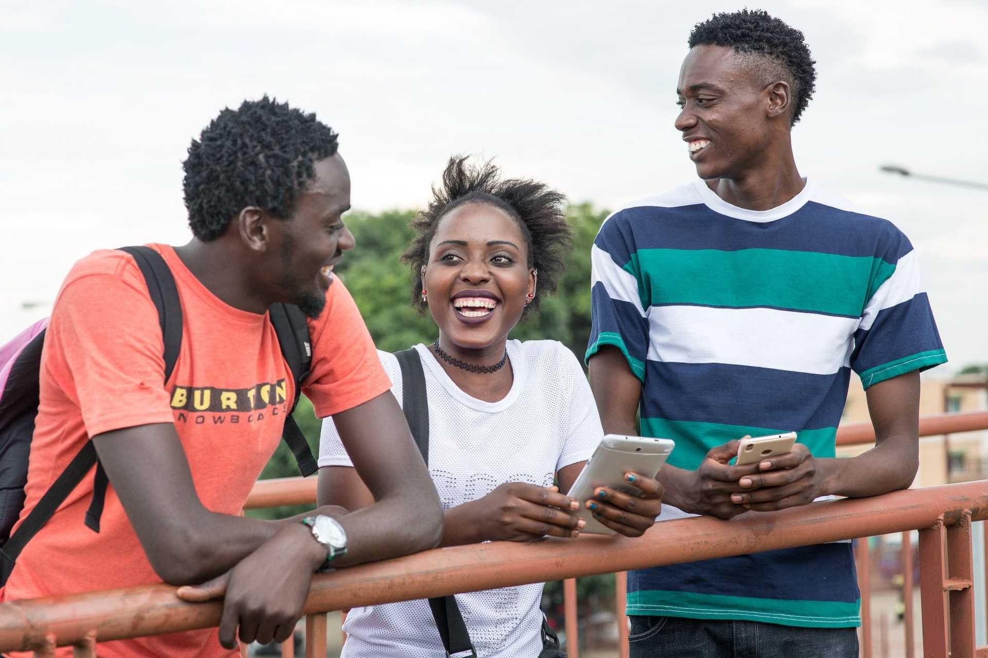 Young people in Zambia smiling on their phones